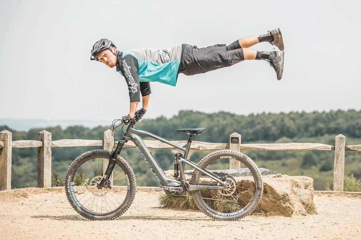 Mann steht mit Kalkhoff-Fahrrad vor dunkler Wand