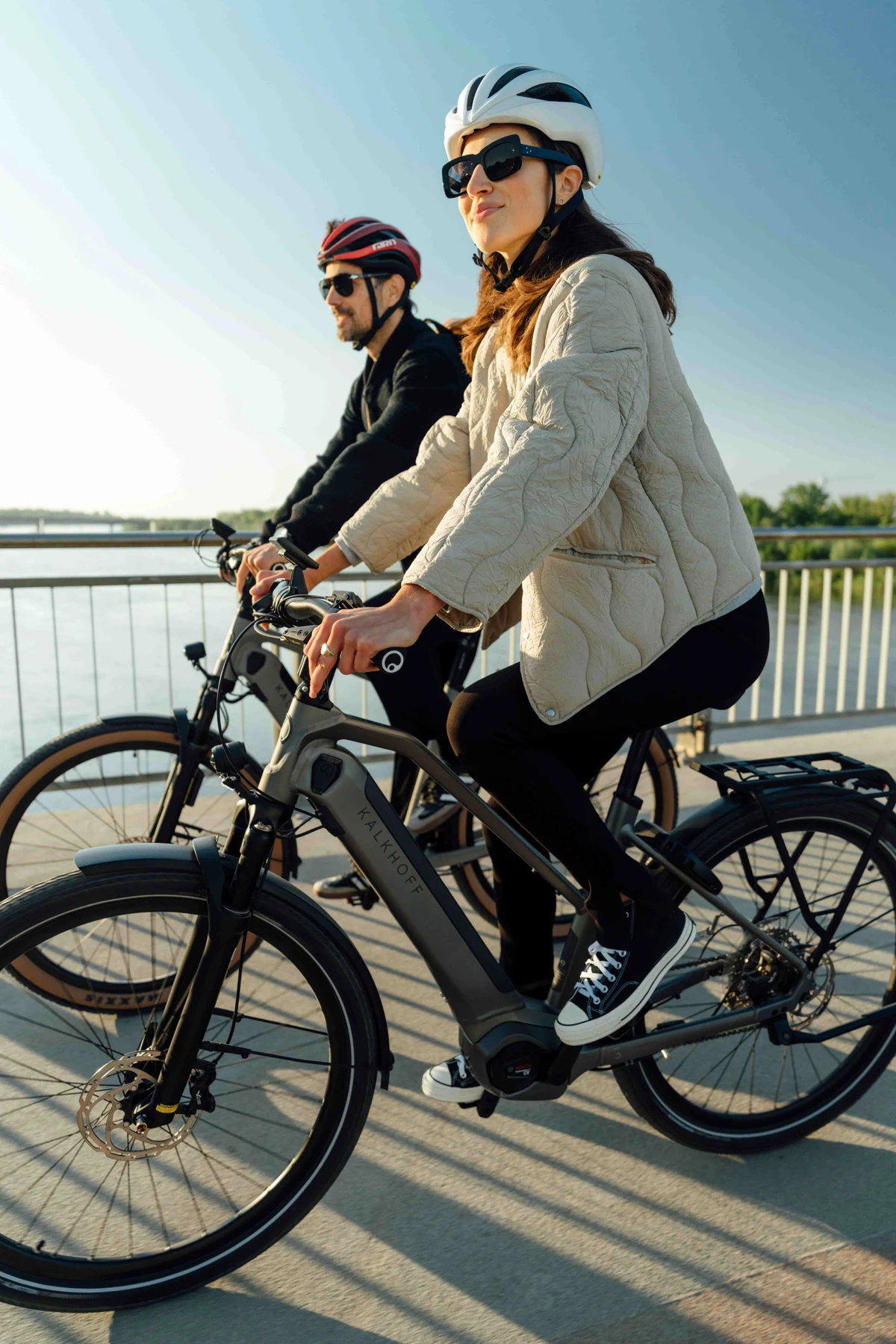 Mann steht mit Fahrrad vor Gebäude auf Platz